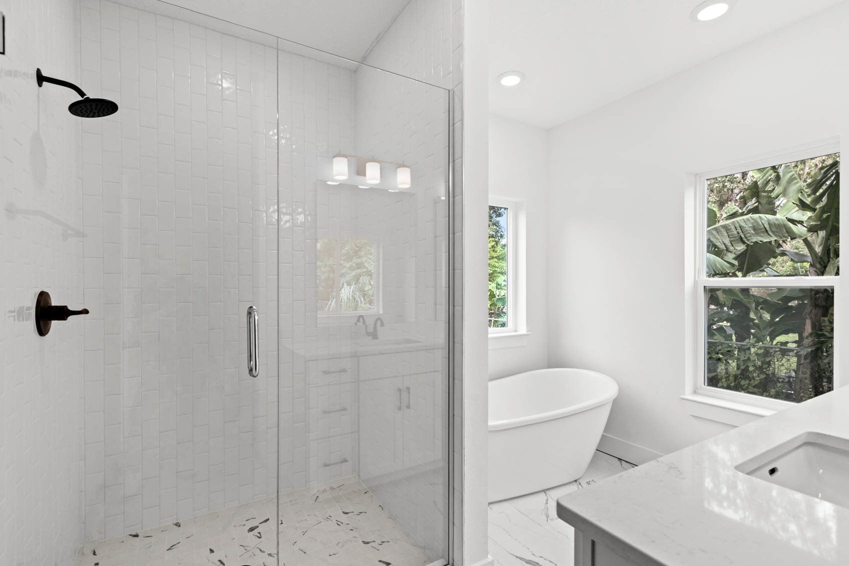 bathroom with glass shower and white tub